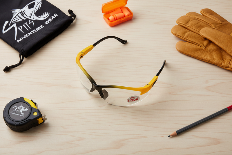 Cougar bifocal safety glasses two-toned black and yellow frame flat lay with work accessories and Spits drawstring bag