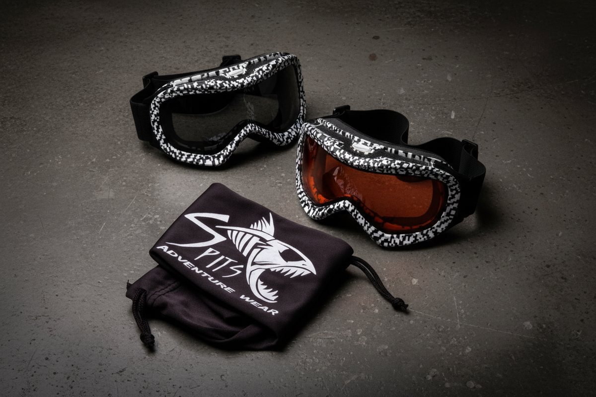 Spits Eyewear Moguls sport goggles lifestyle flat lay – black and white camo checkered frame with gray and orange lens options alongside black drawstring bag